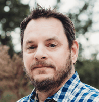 An image of Michael Wood, Global Field CTO at HashiCorp, wearing a blue and white checkered shirt.